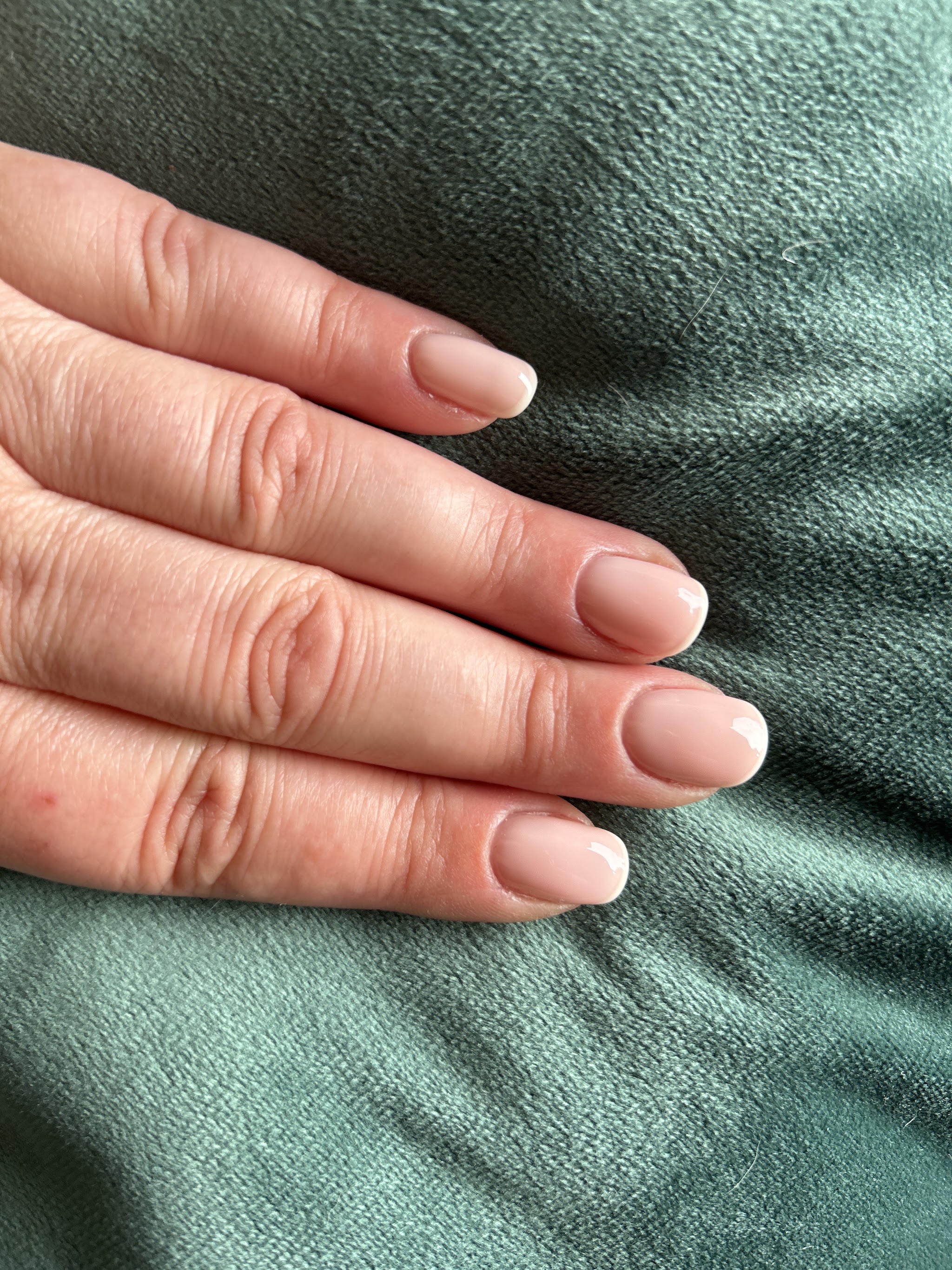 Naturel nude nagels op groen fluweel